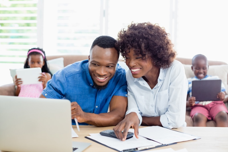 Couple sitting at table and calculating bills at home.